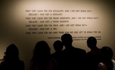 Museum visitors in front of Martin Niemoller quotation